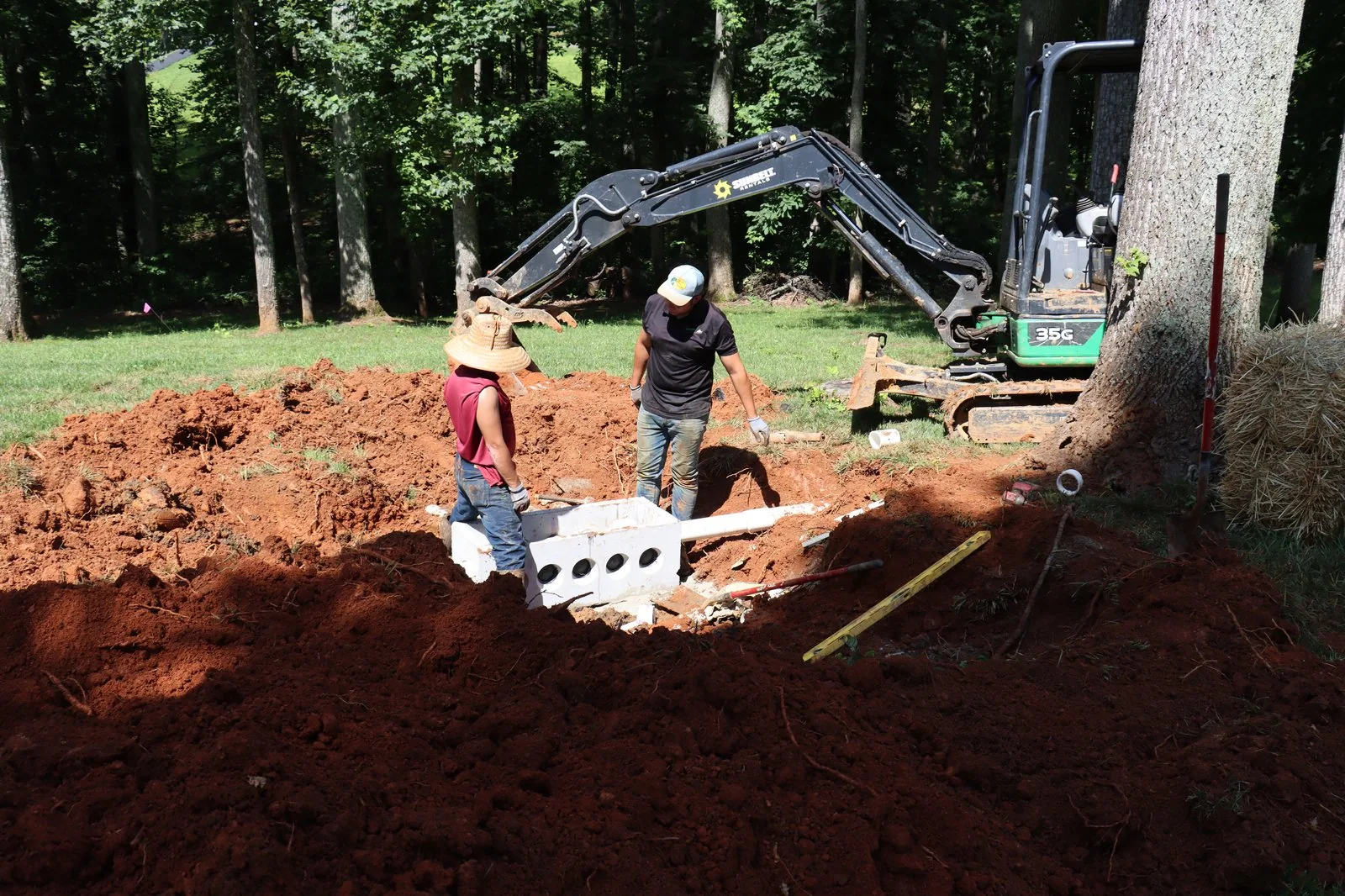 Workers excavating a septic system in a backyard