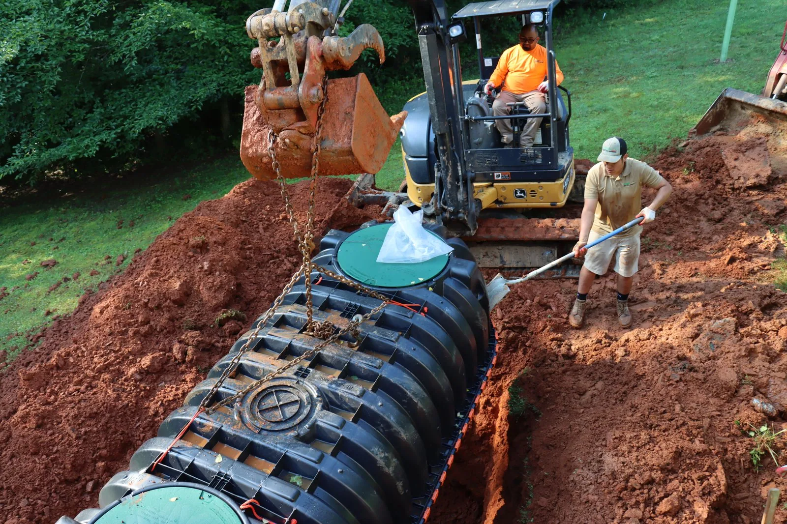 Crew installing a septic tank at a residential site